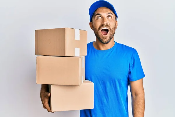 Hombre Guapo Con Barba Vistiendo Uniforme Mensajero Sosteniendo Paquetes Entrega — Foto de Stock