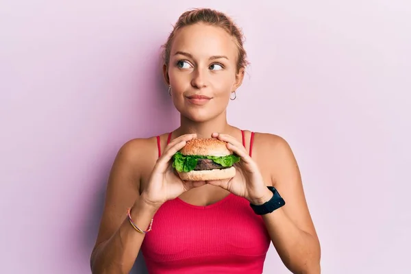 Mooie Blanke Vrouw Die Een Lekkere Klassieke Hamburger Eet Glimlachend — Stockfoto