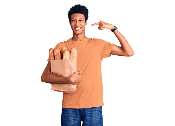 Νεαρός Αφροαμερικάνος Κρατάει Χάρτινη Σακούλα Ψωμί Χαμογελώντας Χαρούμενα Δείχνοντας Και — Φωτογραφία Αρχείου