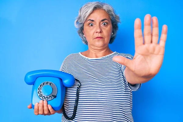 Ältere Hispanische Grauhaarige Frau Hält Ein Telefon Mit Offener Hand — Stockfoto