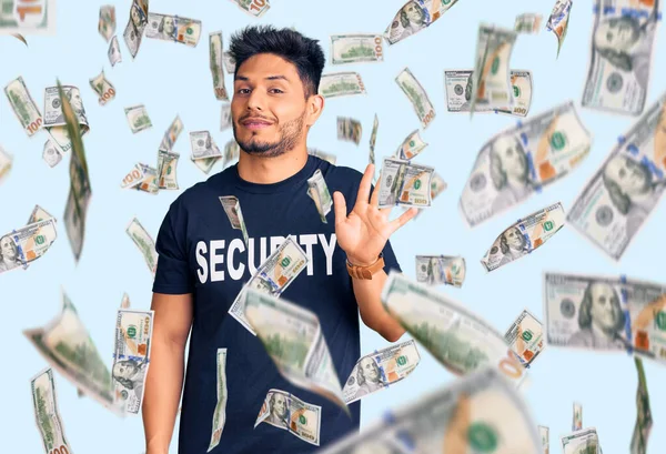 Yakışıklı, Latin Amerikalı, güvenlik tişörtü giyen, feragat eden mutlu, güler yüzlü, dost canlısı bir jest.