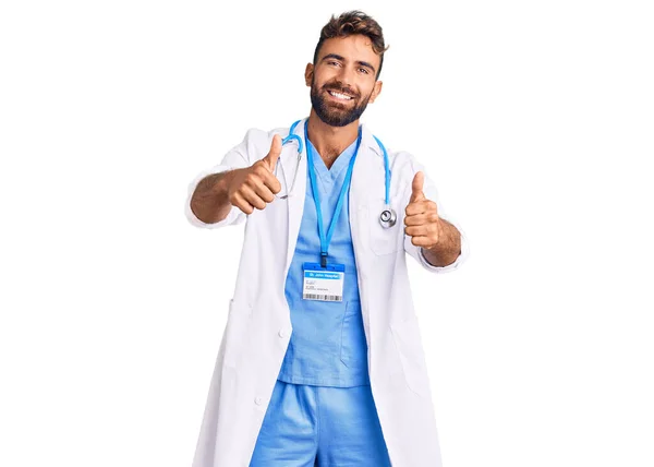 Joven Hispano Vistiendo Uniforme Médico Estetoscopio Aprobando Hacer Gesto Positivo —  Fotos de Stock