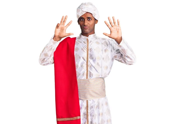 伝統的なSherwaniを身に着けているアフリカのハンサムな男は自信と幸せ笑みを浮かべている間 服が表示され 指の番号9で指摘 — ストック写真