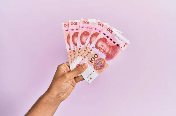 Spaanse Hand Met 100 Chinese Yuan Bankbiljetten Geïsoleerde Roze Achtergrond — Stockfoto