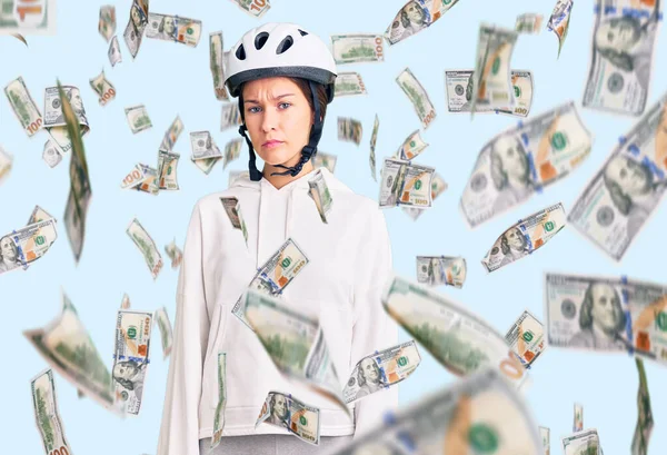 Bisiklet kaskı takan ve spor kıyafetler giyen güzel esmer bir kadın. Yüzünde ciddi bir ifadeyle rahatlamış. Basit ve doğal bir şekilde kameraya bakıyorsun..