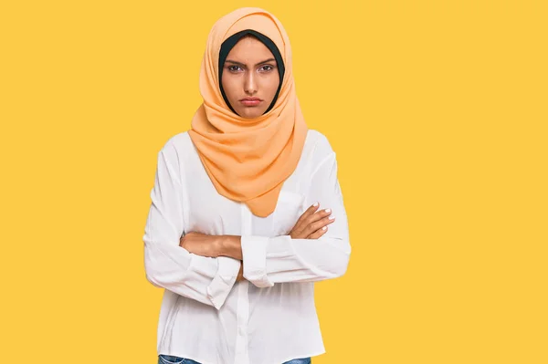 伝統的なイスラムのヒジャーブスカーフを身に着けている若いブルネットの女性は懐疑的で緊張し 両腕を組んで顔に不承認の表現 否定的な人 — ストック写真