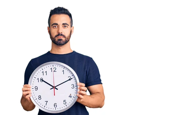 Giovane Uomo Ispanico Possesso Grande Orologio Pensiero Atteggiamento Sobrio Espressione — Foto Stock