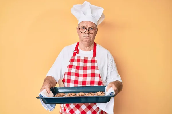 Senior Grey Haired Man Wearing Baker Uniform Holding Homemade Cookies — Stock Photo, Image