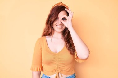 Genç ve güzel bir kadın günlük kıyafetler giyiyor. El hareketleriyle gülümsüyor, gözleriyle mutlu yüzlere bakıyor.. 