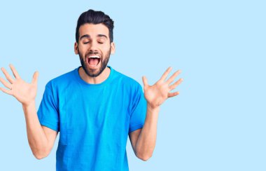 Genç, sakallı, sıradan tişörtlü, çılgın ve başarıyı kolları havada ve gözleri kapalı heyecanla bağırarak kutlayan yakışıklı bir adam. Kazanan konsept 