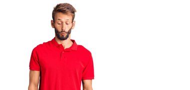 Sarışın, sakallı, sıradan kıyafetler giyen, dudaklı balık suratlı, çılgın ve komik jestler yapan yakışıklı bir adam. Komik ifade. 