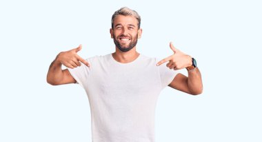 Gündelik tişört giyen genç sarışın adam yanlışlıkla elleri ile ağzını kapatırken şok oldu. gizli kavram. 