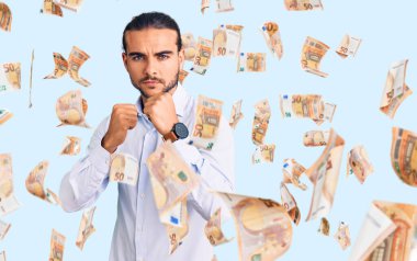 İş kıyafetleri giymiş genç yakışıklı bir adam yumruk savunma hareketiyle dövüşmeye hazır kızgın ve üzgün bir yüz, sorundan korkuyor.