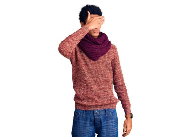 Genç Afro-Amerikan adam sıradan bir kazak ve eşarp giyerek gözlerini kapadı, ciddi ve üzgün görünüyordu. Görme, saklama ve reddetme konsepti 