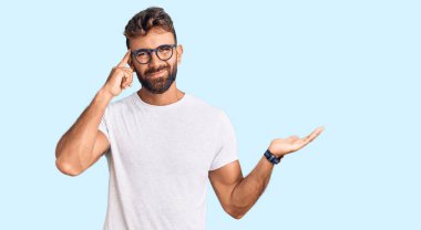 Gündelik kıyafetler giyen ve gözlük takan genç İspanyol adam avuç içi açık fotokopi alanı ve alnını göstermekten rahatsız oluyor. Bunu bir düşün.. 