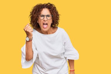 Güzel, orta yaşlı, normal kıyafetler giyen, gözlüklü kızgın, kızgın, sinirli sinirli ve öfkeyle bağıran olgun bir kadın. öfke ve agresif konsept. 