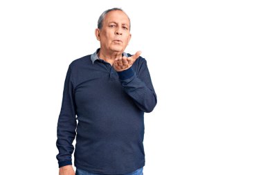 Son sınıf yakışıklısı polo giyen ve kameraya bakıp havada el sallayan bir öpücük atan hoş ve seksi bir adam. aşk ifadesi. 