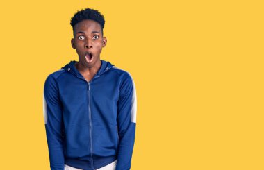 Genç Afro-Amerikan erkek spor giyer. Şaşırmış ve şaşırmış bir ifadeyle, korku ve heyecanlı bir yüzle.. 