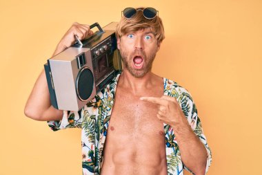 Yaz tarzı giyinmiş genç bir adam, elinde teyp ile korku ve şaşkınlık dolu bir ifade, korku ve heyecan dolu bir yüz tutuyor.. 