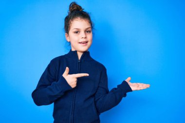 Hoş İspanyol çocuk gündelik giysiler giyip kameraya hayret ediyor ve gülümsüyor.. 