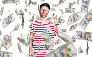 Gündelik kıyafetler giyen genç İspanyol adam kameraya bakıp zafer işareti yaparken parmaklarını gösteriyor. İki numara..