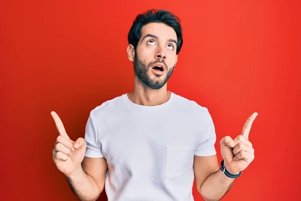 Jovem Hispânico Homem Vestindo Casual Branco Tshirt Espantado Surpreso Olhando — Fotografia de Stock