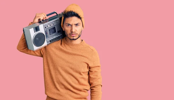 Snygg Latinamerikansk Ung Man Håller Boombox Lyssnar Musik Skeptisk Och — Stockfoto