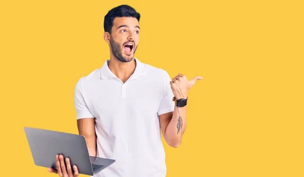 Joven Hombre Hispano Guapo Trabajando Usando Computadora Portátil Apuntando Pulgar — Foto de Stock