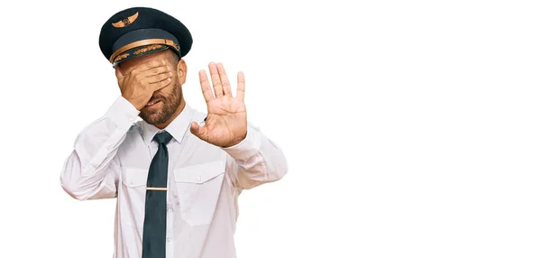 英俊的大胡子男子 身穿飞行员制服 双手蒙住眼睛 以悲伤和恐惧的表情做停止动作 尴尬和消极的概念 — 图库照片