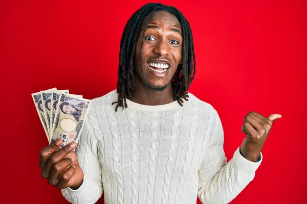 アフリカ系アメリカ人の男性で 5000円の日本円紙幣を持っている人が親指を立てて笑顔で笑顔で口を開けて幸せ — ストック写真
