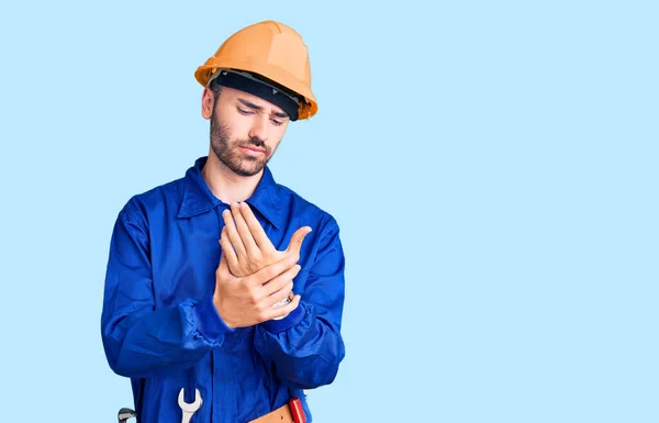 労働者の制服を着た若いヒスパニック系の男手と指の痛み 関節炎の炎症 — ストック写真