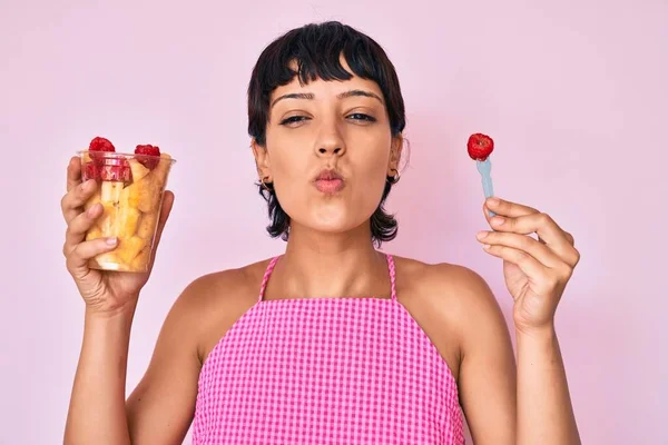 Piękna Brunetka Kobieta Jedzenie Świeże Zdrowe Owoce Patrząc Aparat Dmuchanie — Zdjęcie stockowe