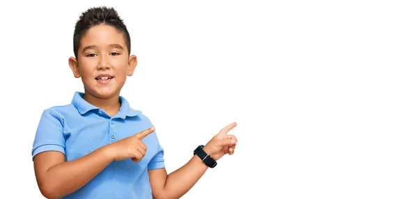 小さな男の子のヒスパニック系の子供を着てカジュアルな服笑顔とカメラを見て2本の手と指で側面を指して — ストック写真
