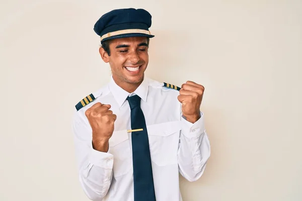 Ung Latinamerikan Man Bär Flygplan Pilot Uniform Firar Förvånad Och — Stockfoto