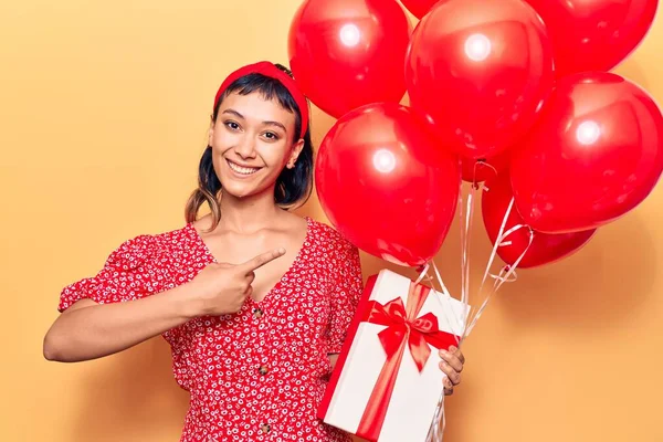 Νεαρή Γυναίκα Κρατώντας Μπαλόνια Δώρο Χαμογελώντας Χαρούμενος Δείχνοντας Χέρι Και — Φωτογραφία Αρχείου