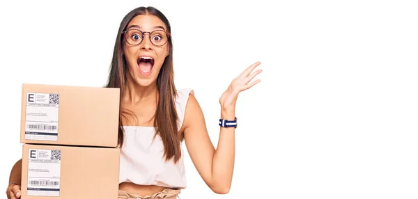 Junge Hispanische Frau Mit Lieferpaket Feiert Sieg Mit Glücklichem Lächeln — Stockfoto