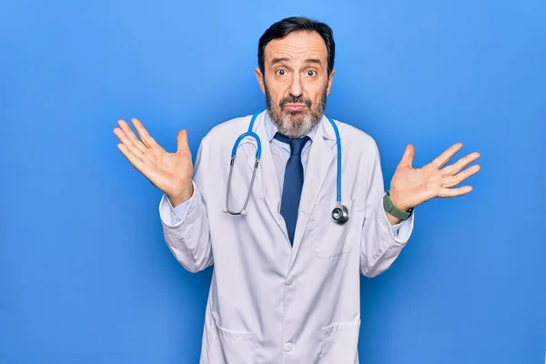 Středního Věku Pohledný Lékař Muž Kabátě Stetoskop Přes Izolované Modré — Stock fotografie