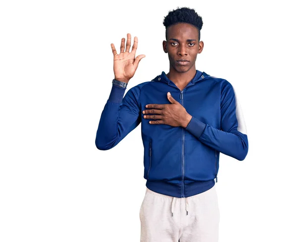 Ung Afrikansk Amerikansk Man Bär Sportkläder Svär Med Handen Bröstet — Stockfoto