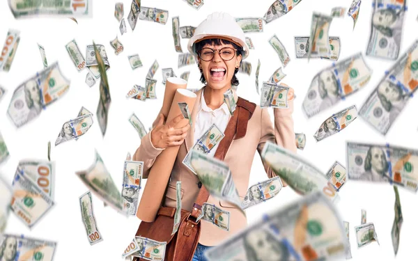 Kısa saçlı, kısa saçlı, güvenlik kaskı takan, elinde planları olan genç esmer kadın gururla bağırıyor, zaferi ve başarıyı kutluyor.