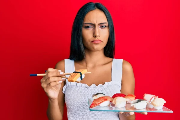 Jovem Morena Comendo Sushi Omelete Usando Pauzinhos Céticos Nervosos Franzindo — Fotografia de Stock