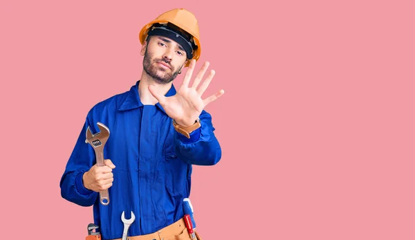 Young Hispanic Man Wearing Electrician Uniform Holding Wrench Open Hand — Stock Photo, Image