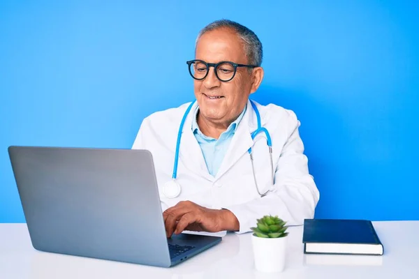 Starszy Przystojny Mężczyzna Siwych Włosach Noszący Mundur Lekarza Pracujący Laptopie — Zdjęcie stockowe