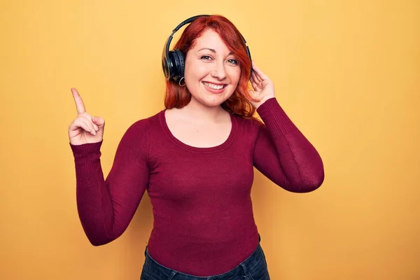 Genç Güzel Kızıl Saçlı Müzik Dinleyen Sarı Arka Planda Kulaklık — Stok fotoğraf