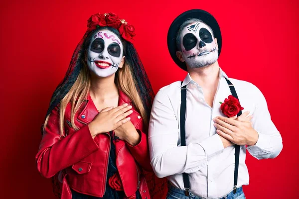 死んだ衣装の日を身に着けているカップルは 目を閉じて胸に手で笑顔と顔に感謝のジェスチャー 健康の概念 — ストック写真