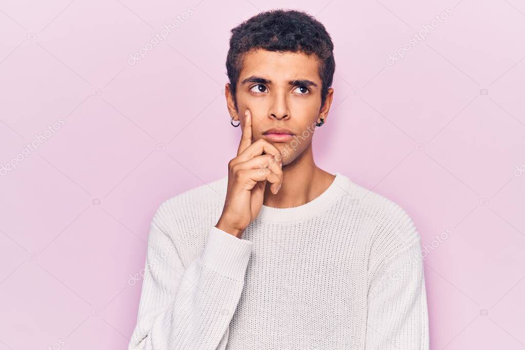 Young african amercian man wearing casual clothes thinking concentrated about doubt with finger on chin and looking up wondering 