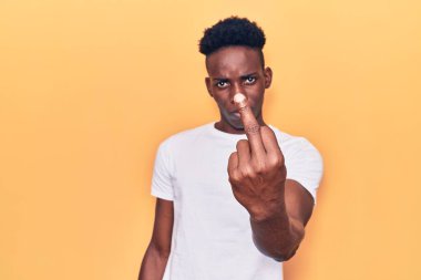 Young african american man wearing casual clothes showing middle finger, impolite and rude fuck off expression 