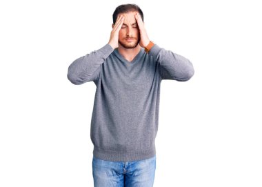 Genç, beyaz, sıradan bir kazak giyen, baş ağrısı çeken, çaresiz ve stresli bir adam. Çünkü acı ve migren ağrısı var. Eller başının üstünde.. 