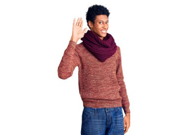 Sıradan bir kazak ve eşarp giyen genç Afro-Amerikan adam merhaba diyor mutlu ve gülümseyen, dostça bir hoş geldin jesti. 