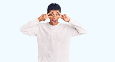 Genç Afrikalı Amerikalı sıradan kıyafetler giyen, barış sembolü yapan, parmaklarının üzerinde gülümseyerek zaferi gösteren. 