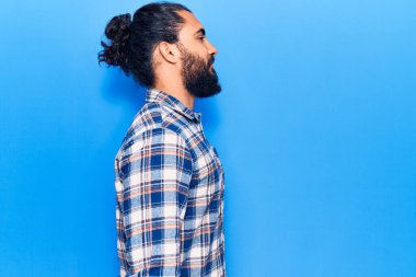 Gündelik giysiler giyen genç bir Arap, rahat bir görünüm takınıyor, kendine güvenen bir gülümsemeyle doğal bir yüz ifadesi sergiliyor.. 